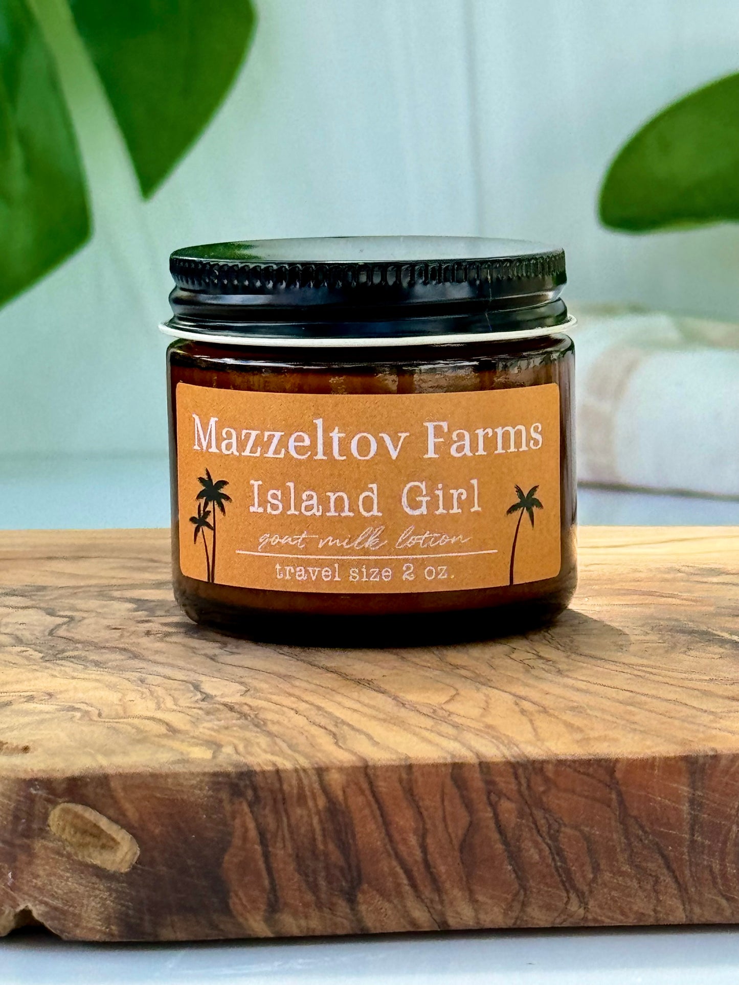 Island Girl goat milk lotion in small amber glass jar with twist cap, tropical fruity scented natural lotion