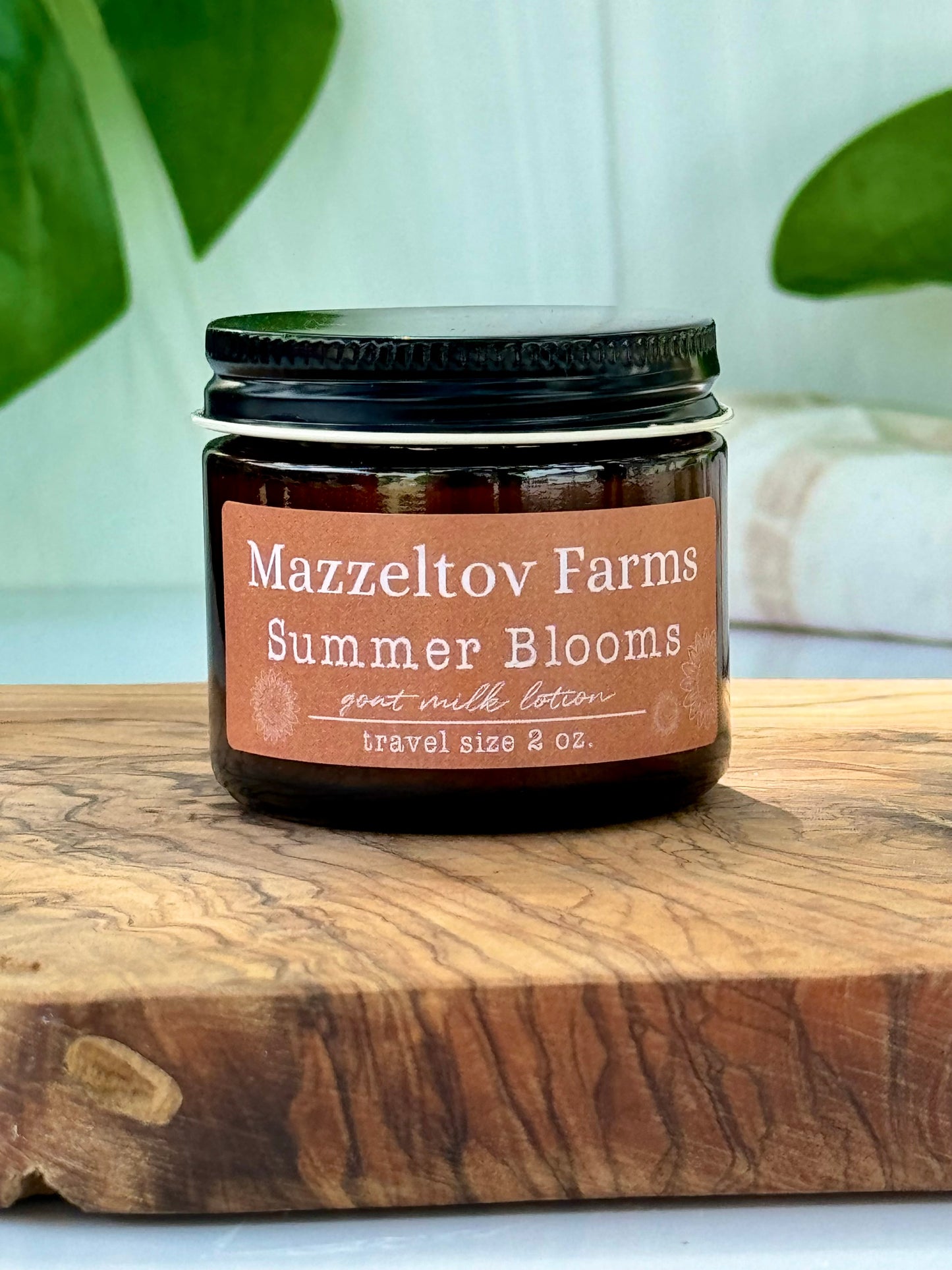 Summer Blooms goat milk lotion in small amber glass jar with twist cap, fruity floral scented natural lotion for soft hydrated skin