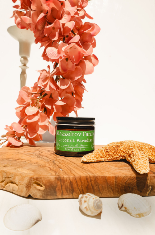 Coconut Paradise goat milk lotion in small amber glass jar with twist cap, coconut scented natural lotion with coastal fragrance