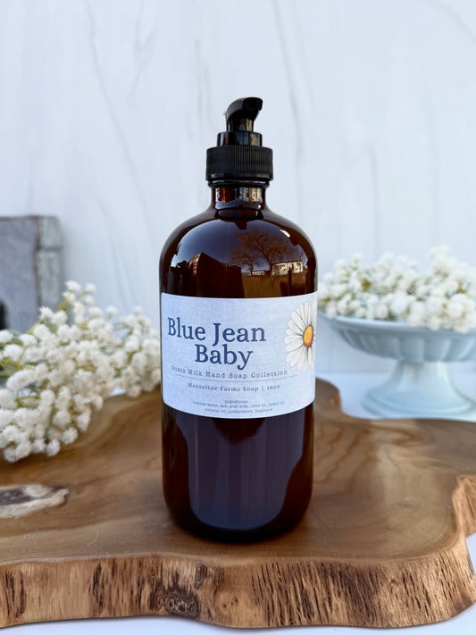 Blue Jean Baby goat milk liquid hand soap in a 16 oz amber glass bottle with pump by Mazzeltov Farms Soap Co. Bright floral spring scent with soft musk and sandalwood.