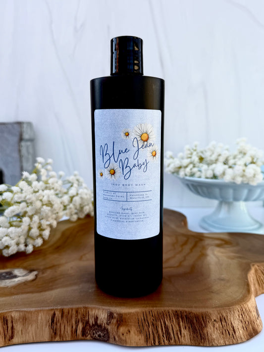Blue Jean Baby goat milk body wash in a 16 oz black squeeze bottle by Mazzeltov Farms Soap Co. Bright floral spring scent with lily, freesia, citrus, and soft musk.