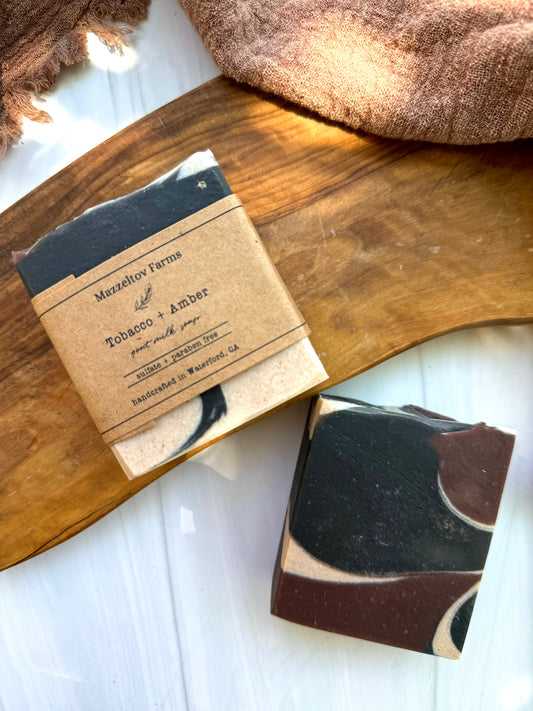 Tobacco and Amber goat milk soap bar handmade by Mazzeltov Farms Soap Co. Black and tan marbled bar with warm musky notes of tobacco, amber, and sandalwood.