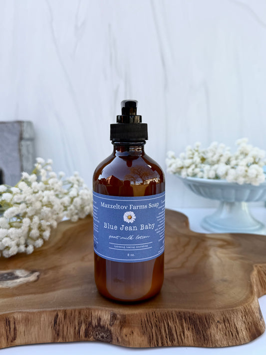 Blue Jean Baby goat milk lotion in an 8 oz bottle by Mazzeltov Farms Soap Co. Bright floral spring scent with lily, freesia, citrus, and soft musk.