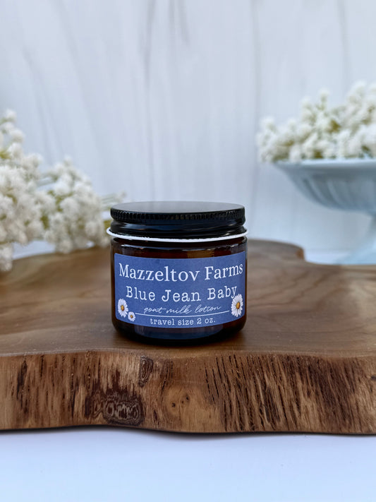 Blue Jean Baby goat milk lotion in a 2 oz jar by Mazzeltov Farms Soap Co. Bright floral spring scent with lily, freesia, citrus, and soft musk.