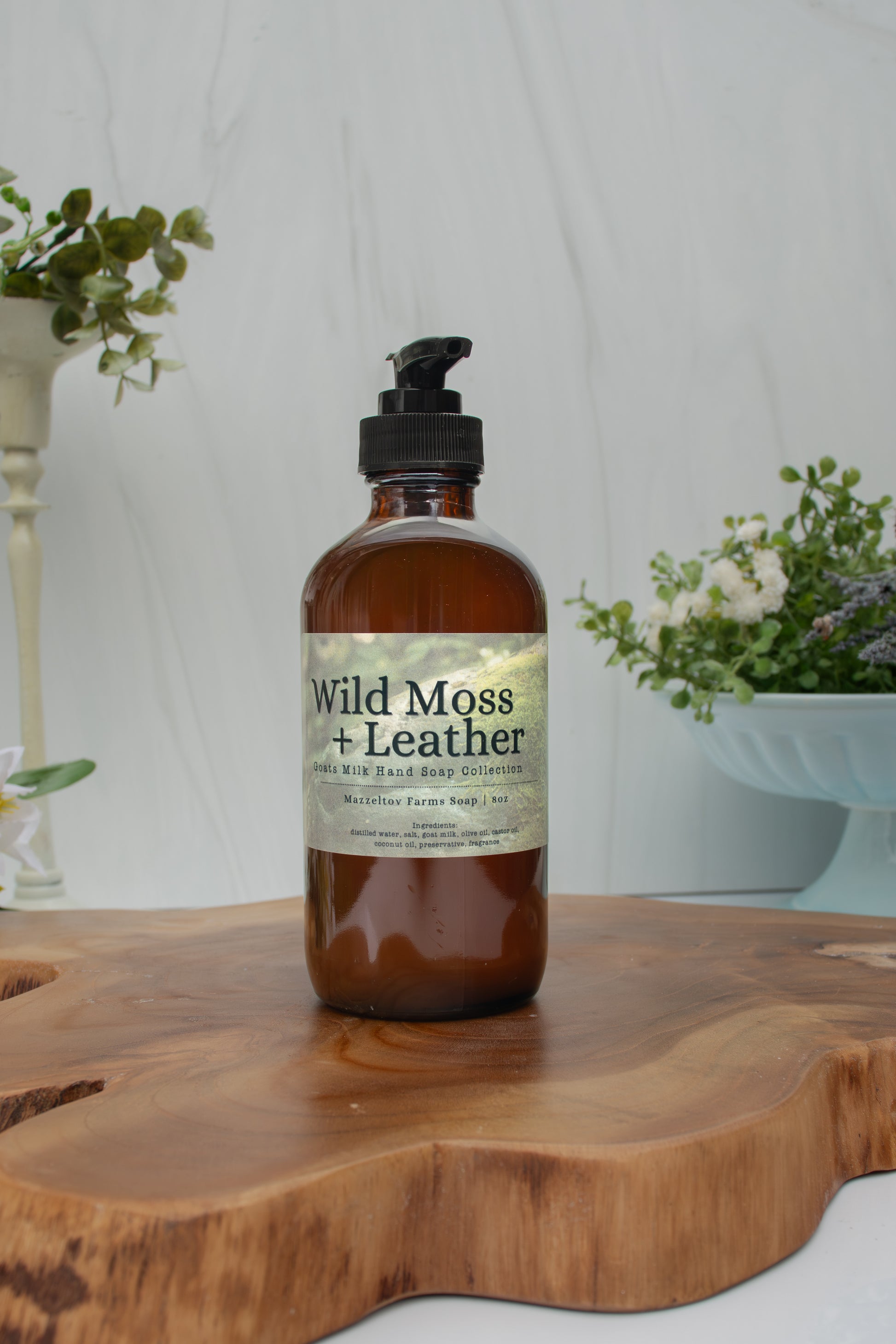 Wild Moss + Leather goat milk liquid hand soap by Mazzeltov Farms Soap Co. 8 oz amber glass bottle with pump and a rich earthy scent of amber, leather, oakmoss, sage, and lavender.