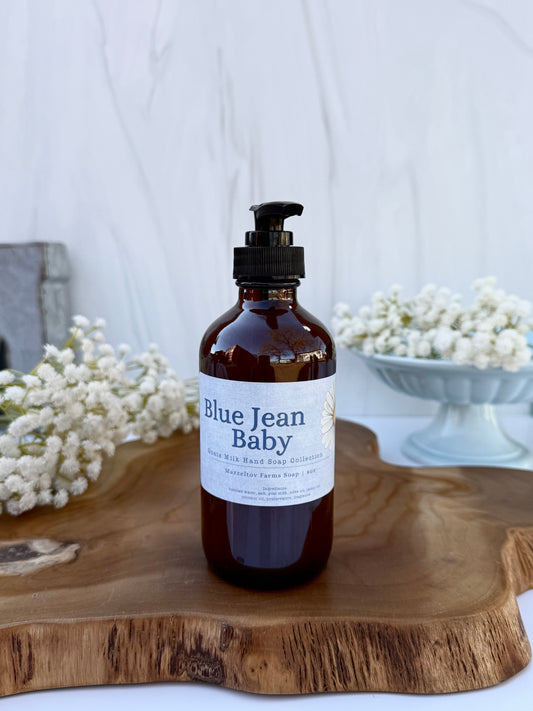 Blue Jean Baby goat milk liquid hand soap in an 8 oz amber glass bottle with pump by Mazzeltov Farms Soap Co. Bright floral spring scent with soft musk and sandalwood.
